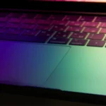Vibrant and modern laptop keyboard illuminated with neon colors, showcasing technology glow.