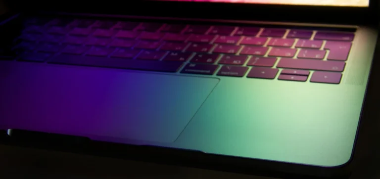 Vibrant and modern laptop keyboard illuminated with neon colors, showcasing technology glow.
