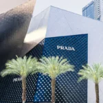 Contemporary architecture of the Prada storefront on Las Vegas Strip with palm trees and unique design.