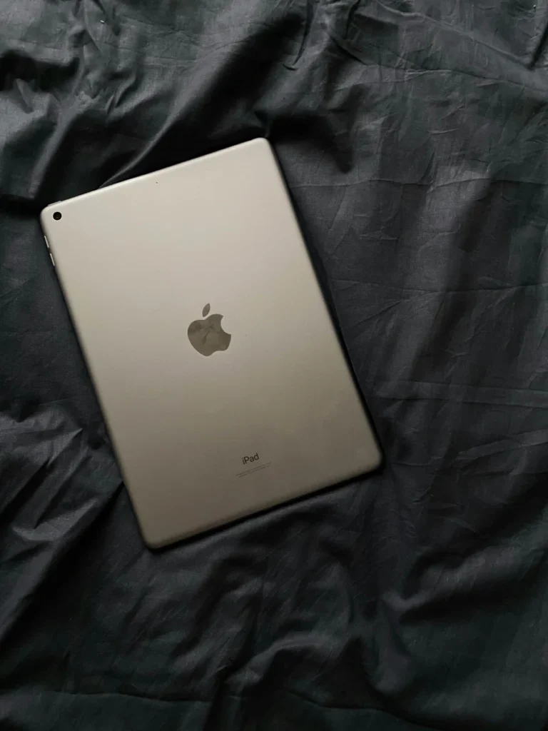Minimalist shot of an Apple iPad on a crumpled dark fabric background.