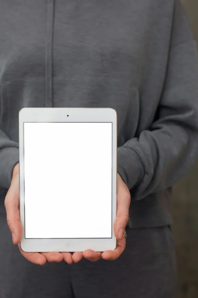 Close-up of hands holding a tablet with a blank screen, suitable for app mockups.