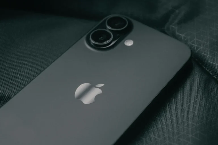 Detailed close-up of a modern smartphone on a textured dark fabric background.