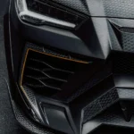 Detailed shot of a luxury sports car's front with carbon texture and sleek design.