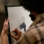Close-up of an artist drawing a portrait in a studio setting.