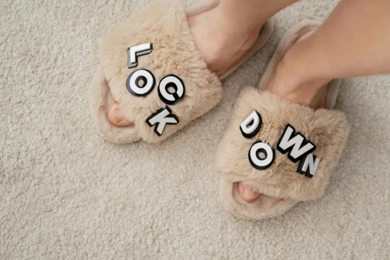 Furry slippers with 'Lockdown' text and feet on a soft carpet - a cozy home vibe.