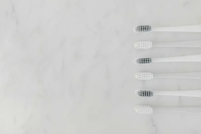 A minimalist image of six toothbrushes arranged on a marble surface, offering a clean and modern aesthetic.