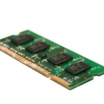 Detailed view of a green electronic memory module against a white background, showcasing modern technology.