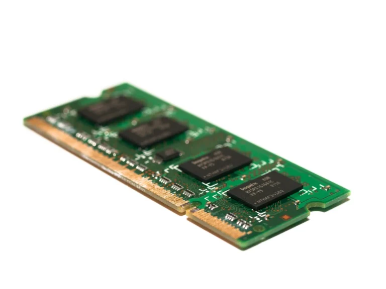 Detailed view of a green electronic memory module against a white background, showcasing modern technology.