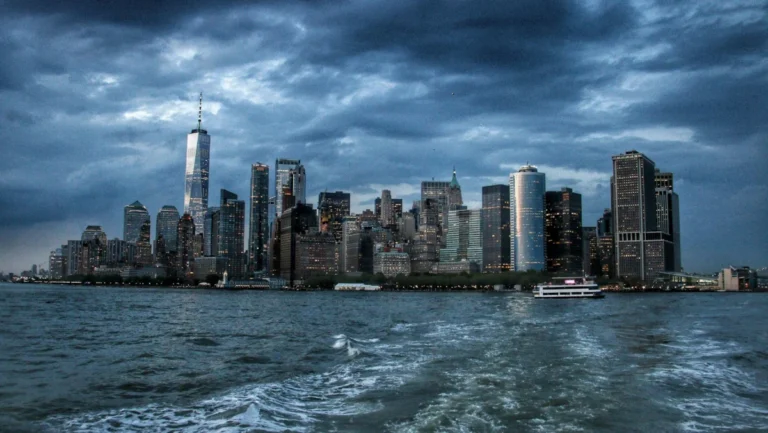 Dramatic view of New York City skyscrapers against a moody twilight sky.