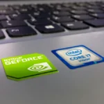 Detailed close-up of a laptop keyboard featuring Intel Core i7 and NVIDIA GeForce stickers, highlighting technology components.