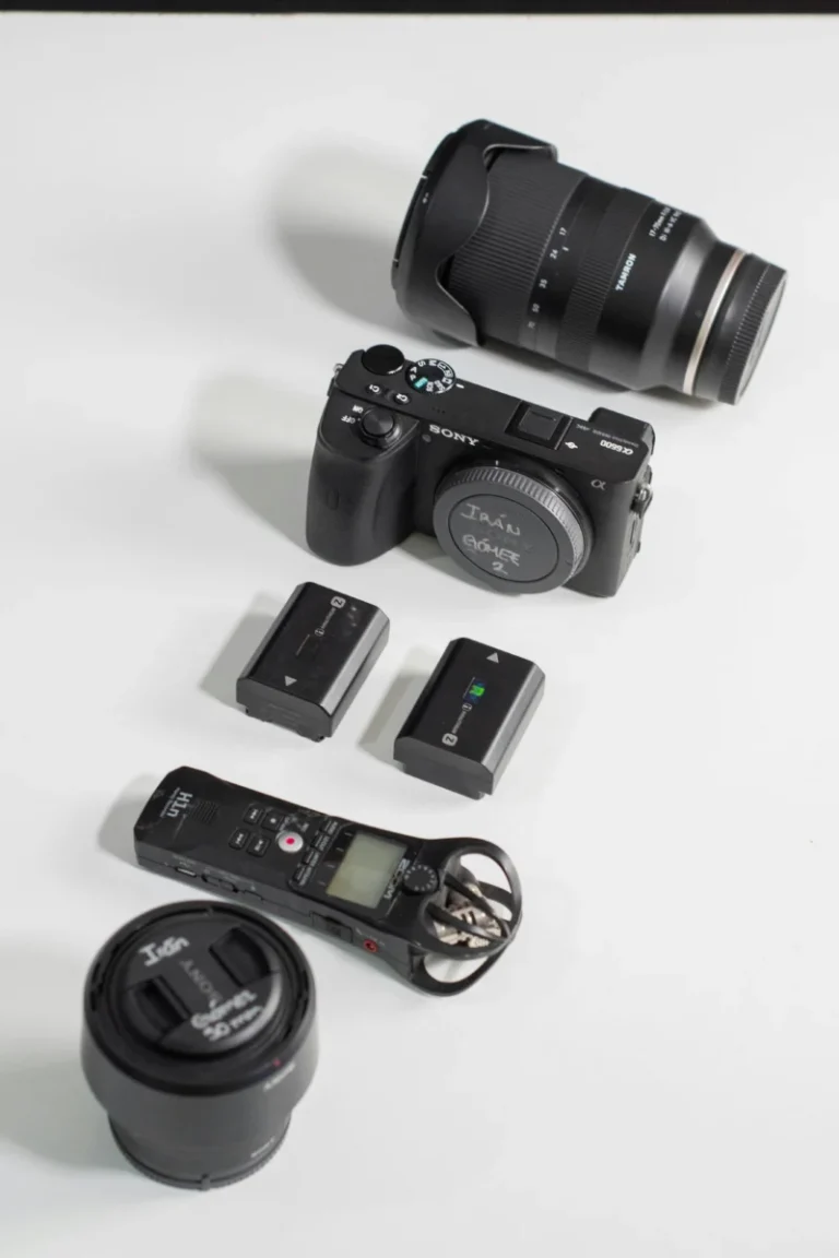 A flat lay display of photography gear including a camera, lenses, and accessories.