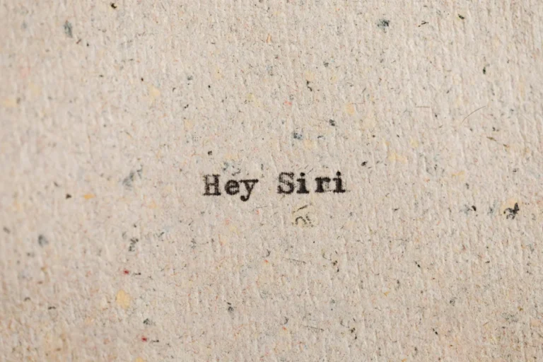 Close-up view of 'Hey Siri' text printed on recycled paper, conceptual art.