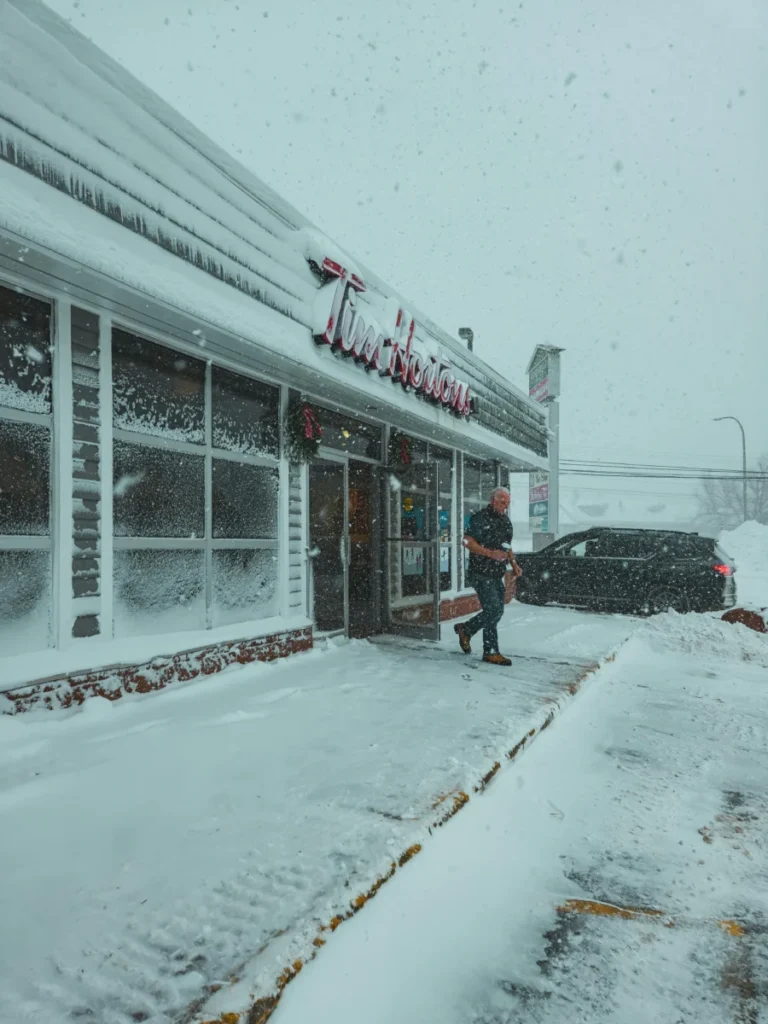 Découvrez l’allocution complète de Tim Cook sur les projets d’Apple pour ses 50 ans A snowy day outside a Tim Hortons with a person walking to a car.