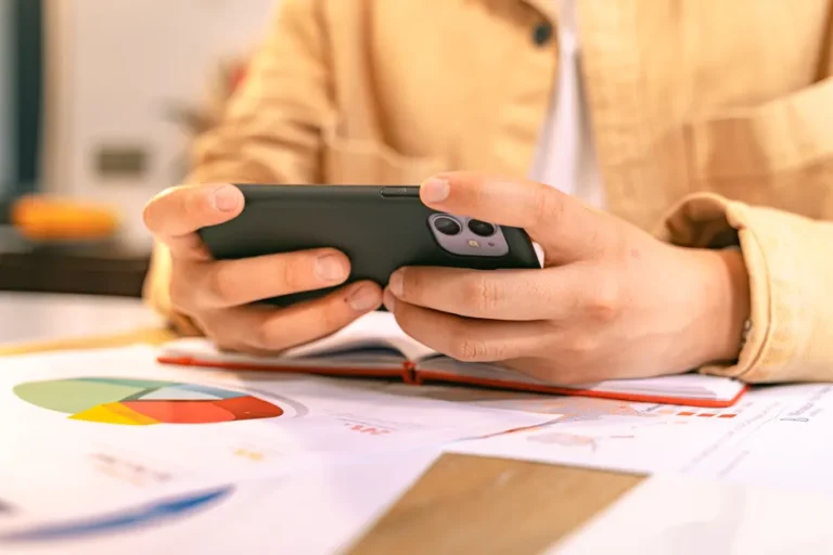 Apple TV à 5,99 $ pendant six mois jusqu’au 1er décembre 2025 : le septième mois pique A business person checking their phone while working with graphs and charts on a desk.