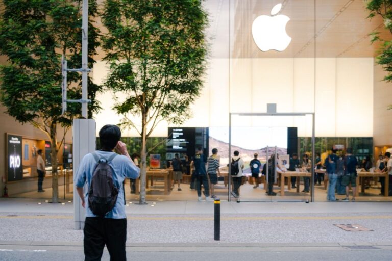 Apple ouvre son sixième Store à Pékin le 6 décembre 2025, Vision Pro en démo A busy Apple Store entrance with glass facade, trees, and people milling around.