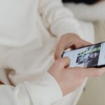 Apple Sports arrive dans 20 pays européens le 17 novembre 2025, sans diffuser les matchs A close-up view of hands holding a smartphone displaying a sports image indoors.