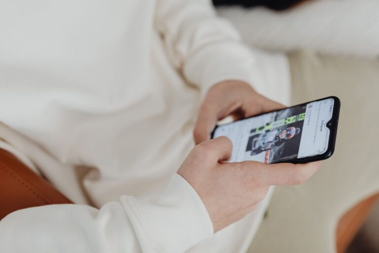 Apple Sports arrive dans 20 pays européens le 17 novembre 2025, sans diffuser les matchs A close-up view of hands holding a smartphone displaying a sports image indoors.