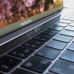 MacBook Pro M6 : l'OLED pourrait rester aux versions Pro et Max jusqu'en 2027 A detailed close-up of a MacBook Pro keyboard, highlighting keys and reflection.