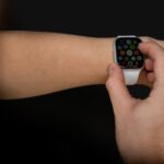 Apple Watch Series 10 à 279 dollars chez Amazon: la taille joue à cache-cache A person interacts with a touchscreen smartwatch against a black background, showcasing modern technology.