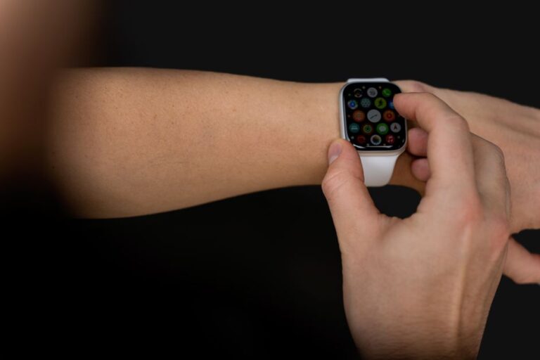 Apple Watch Series 10 à 279 dollars chez Amazon: la taille joue à cache-cache A person interacts with a touchscreen smartwatch against a black background, showcasing modern technology.