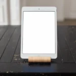 A sleek tablet with a blank screen displayed on a rustic wooden table, perfect for mockups.