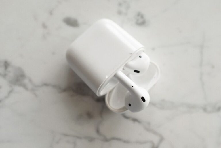 AirPods 4 à 69 dollars le 26 novembre 2025 : le choix de l’ANC A top-view photo of wireless earbuds in a case, placed on a marble surface, showcasing modern technology.