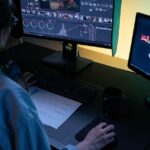 VideoProc Converter AI sur Mac : la 4K ne ressuscite pas les pixels A video editor using dual monitors for editing footage in a dimly lit studio.