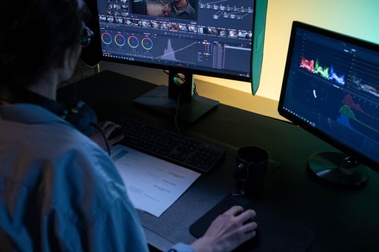 VideoProc Converter AI sur Mac : la 4K ne ressuscite pas les pixels A video editor using dual monitors for editing footage in a dimly lit studio.