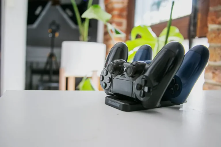 Belkin UltraCharge Pro 3-en-1 à 25 W : le dock qui évite le nid de câbles A wireless game controller resting on a charging dock in a modern indoor setting, showcasing gaming technology.
