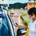 Digital ID sur iPhone le 12 novembre 2025 : le passeport reste aux frontières A woman checks a driver's temperature at a roadside checkpoint during COVID-19 pandemic.