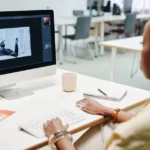 Adobe Creative Cloud Pro à 34,97 $ pendant un an : l'offre finit le 28 novembre 2025 A woman using a computer for image editing in a bright, modern office setting.