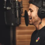 Apple Watch Series 4 à Ultra 2 : l’ECG aide, le diagnostic attendra A young male musician singing in a professional recording studio with a microphone and headphones.