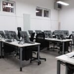 Hackintosh sous macOS Tahoe 26 : le dernier boot avant macOS 27 An empty computer lab featuring multiple vacant workstations with modern monitors.