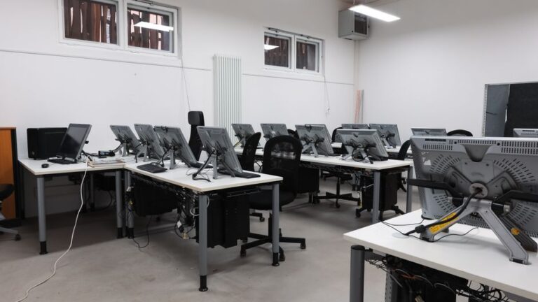 Hackintosh sous macOS Tahoe 26 : le dernier boot avant macOS 27 An empty computer lab featuring multiple vacant workstations with modern monitors.