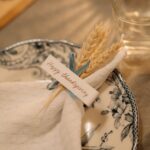 A Charlie Brown Thanksgiving gratuit les 15 et 16 novembre 2025, Snoopy remet le couvert Beautiful Thanksgiving table setting with decorated plate and napkin featuring wheat and a festive greeting card.