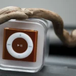 iPod : 1 000 chansons le 10 novembre 2001, puis l’iPhone lui coupe le son Close-up of a compact music player encased in clear plastic with wooden element.