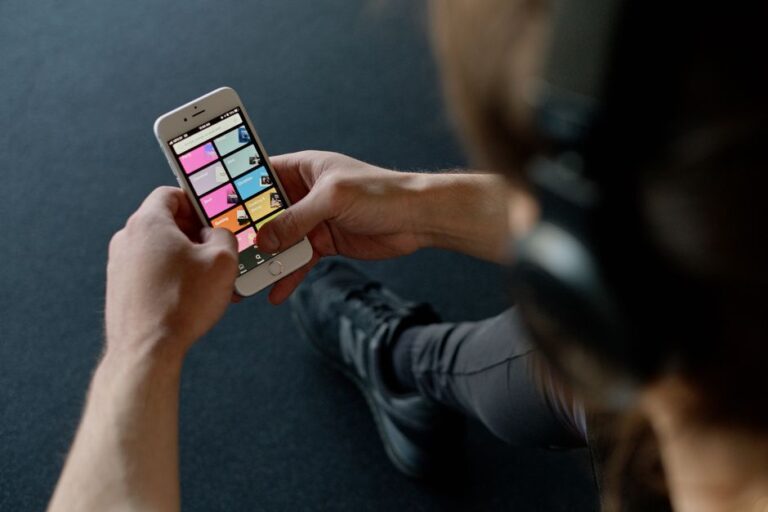 Apple Fitness+ à 9,99 dollars : le projet Health+ en 2026 Close-up of a person listening to music on a smartphone while at the gym, focusing on a streaming playlist app.