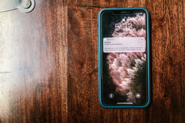 Arnaques iMessage : Singapour ordonne le blocage des faux messages officiels le 25 novembre 2025 Close-up of a smartphone displaying a fraud alert message on a wooden table.