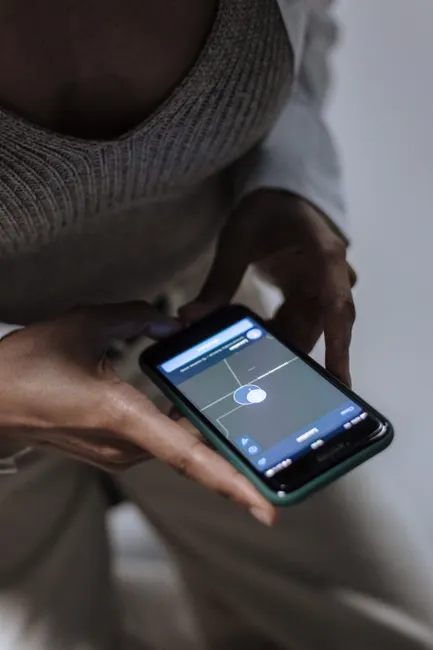 Close-up of a woman holding a smartphone with GPS navigation displayed, emphasizing technology and connectivity.