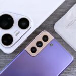 Pixel Pro 10 contre iPhone 17 Pro : Google rejoue Wicked en 60 secondes Close-up of two smartphones with camera focus on a textured wooden surface.
