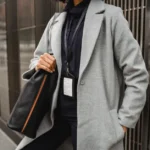 iPhone Pocket à 150 ou 230 dollars : stock épuisé aux États-Unis Crop anonymous female employee with badge standing with hand in pocket and shoulder bag on city pavement
