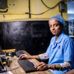iPhone : environ 20 % assemblés en Inde en 2025, la mécanique Foxconn reste saisonnière Female factory worker operating a computer in an industrial setting, highlighting modern textile manufacturing.