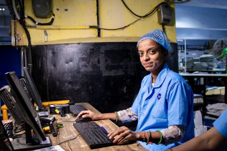 iPhone : environ 20 % assemblés en Inde en 2025, la mécanique Foxconn reste saisonnière Female factory worker operating a computer in an industrial setting, highlighting modern textile manufacturing.