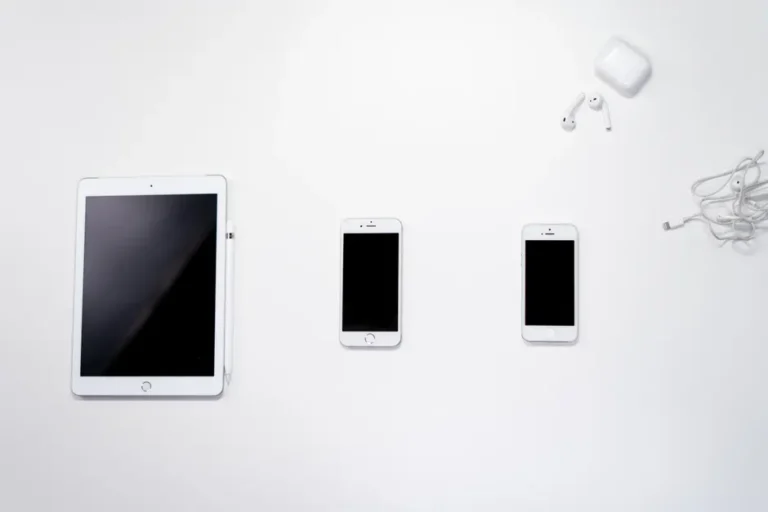 iPhone Air 2 : retard supposé, iPod Sock et Vision Pro sur le pont Flat lay of smartphone, tablet, and earphones arranged on a white surface for a clean, minimalist aesthetic.