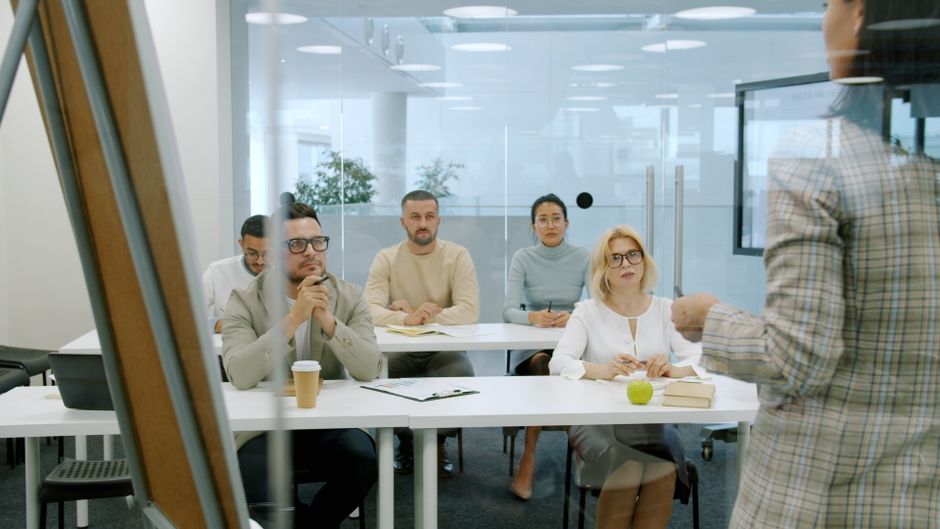 Group of professionals engaged in a meeting in a sleek, modern office setting.