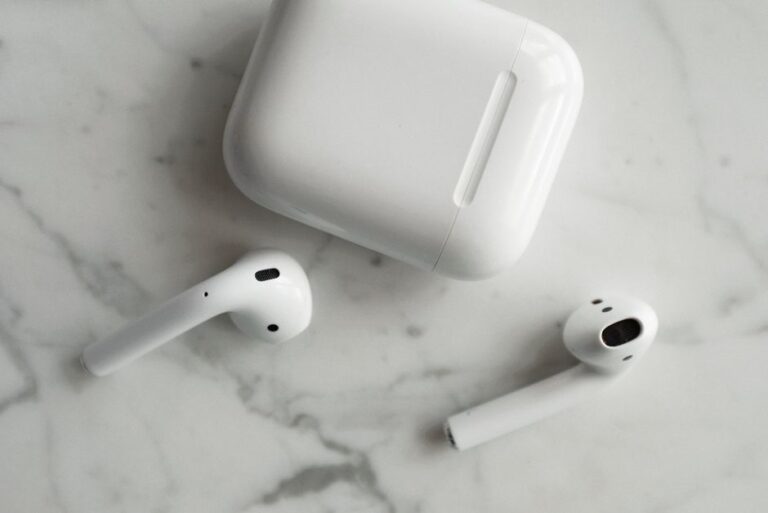 AirPods 4 à 69 dollars le 26 novembre 2025 : l’ANC reste au vestiaire High-quality image of wireless earbuds and charging case on marble surface, showcasing modern technology.
