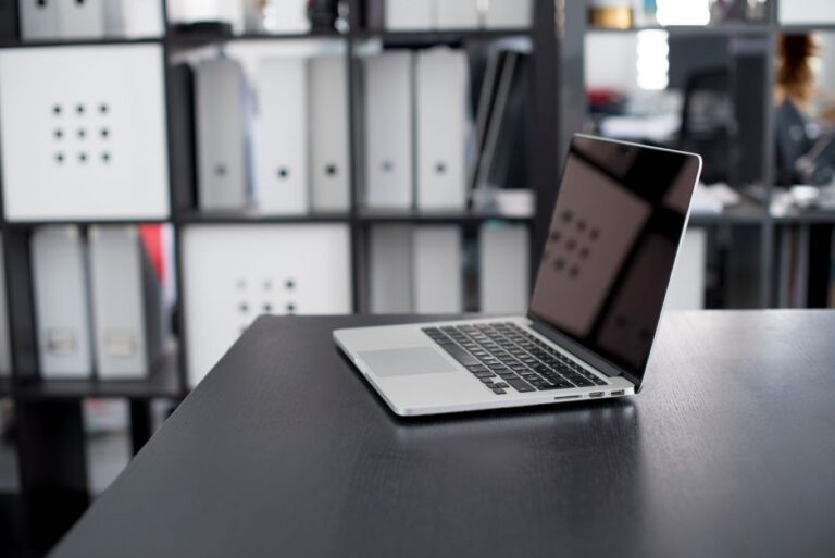 MacBook Pro M5 1 To à 1 499 $ : le prix qui pique MacBook Pro displayed on a minimalist office desk with shelves in the background.