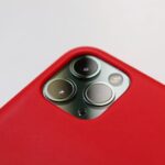 Brevets photo de l’iPhone : Apple gagne le dernier round le 17 novembre 2025 Macro shot of a smartphone camera with a red case, highlighting lens detail.