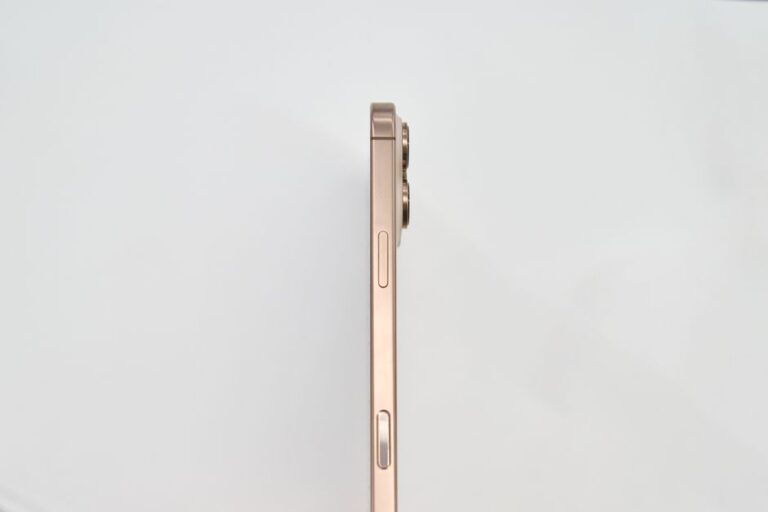 iOS 26.2 bêta 3 : le bouton latéral s’ouvre au Japon, Siri grogne Minimalist side view of a gold smartphone on white background.