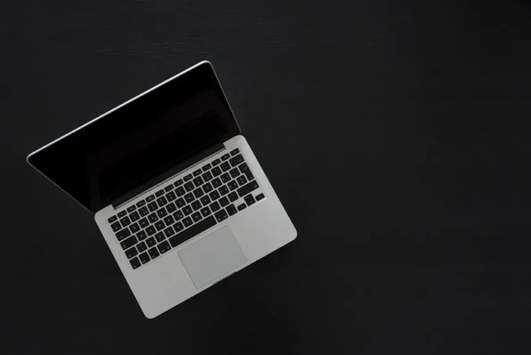 MacBook A18 Pro : 699 à 900 dollars, le pari qui coince Overhead view of a MacBook laptop on a dark desk, showcasing modern technology and minimalism.